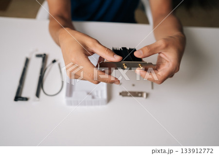 Close-up of technician hands installing wi-fi module with heatsink into computer, upgrading wireless network card for improved connectivity. Concept of desktop PC maintenance and service. 133912772