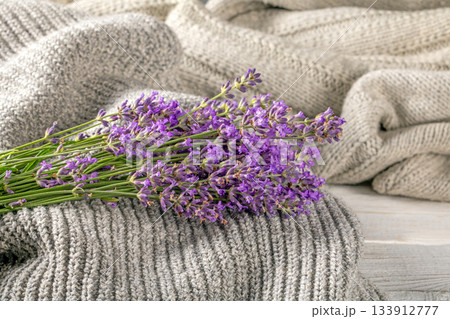 Charming lavender bouquet set on warm, textured knitted textiles 133912777