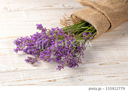 Lush bouquet of lavender flowers displayed attractively on rustic wooden furniture Lush bouquet of lavender flowers displayed attractively on rustic wooden furniture 133912779