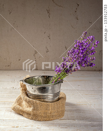 Elegant lavender arrangement in metal bucket with rough plaster backdrop Elegant lavender arrangement in metal bucket with rough plaster backdrop 133912783