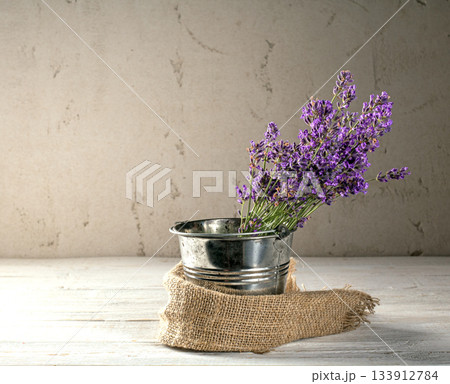 Charming lavender bouquet in a small metal bucket on a rustic plaster background 133912784