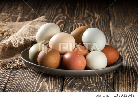 Charming display of eco-conscious chicken eggs on rustic wooden farm table Charming display of eco-conscious chicken eggs on rustic wooden farm table 133912948
