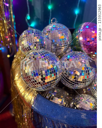 Christmas Silver disco ornaments catching light with festive reflections. Christmas market atmosphere, party celebration and glitter mood, winter sparkle, holiday brightness and joyful seasonal decor. Christmas Silver disco ornaments catching light with festive reflections. Christmas market atmosphere, party celebration and glitter mood, winter sparkle, holiday brightness and joyful seasonal decor. 133912963