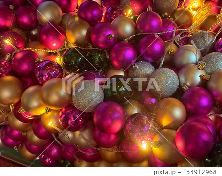 Christmas baubles glowing with warm fairy lights in festive vibrant color palette. Holiday joy, seasonal decoration mood, cozy winter celebration and sparkling atmosphere. 133912968