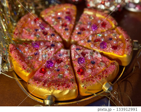 Christmas bauble Glitter pizza slices covered with gems and beads as decorative Christmas piece. Celebration fun, creative holiday styling, whimsical festive accents and joyful seasonal sparkle. 133912991