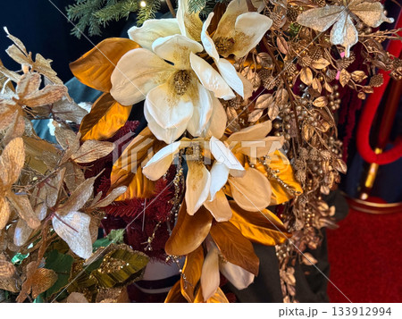 Golden floral arrangement with magnolia petals and shimmering foliage for Christmas decor. Winter luxury, festive interior styling and elegant celebration mood and seasonal design inspiration. 133912994