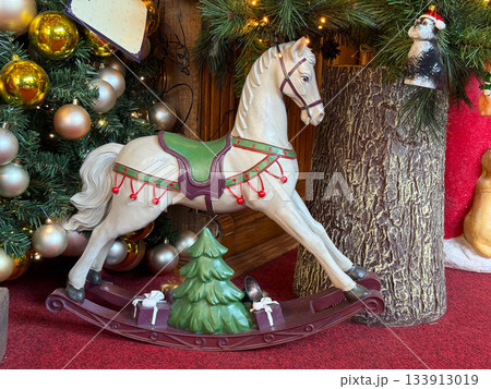 Christmas rocking horse surrounded by festive ornaments and gifts. Nostalgic charm, joyful tradition and warm winter storytelling creating enchanting holiday spirit and decorative atmosphere Christmas rocking horse surrounded by festive ornaments and gifts. Nostalgic charm, joyful tradition and warm winter storytelling creating enchanting holiday spirit and decorative atmosphere 133913019
