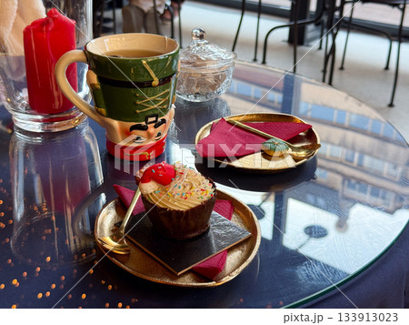Christmas dessert setting with nutcracker mug and festive cupcake. Warm celebration, seasonal charm and joyful winter storytelling enhancing cozy atmosphere and decorative holiday mood 133913023