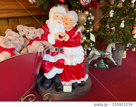 Santa and Mrs Claus sharing a gentle moment near Christmas holiday decor. Warm connection and festive storytelling that conveys seasonal togetherness. Santa and Mrs Claus sharing a gentle moment near Christmas holiday decor. Warm connection and festive storytelling that conveys seasonal togetherness. 133913234