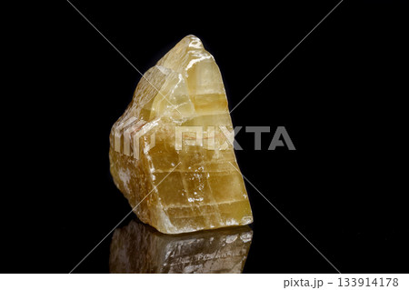 Macro mineral stone yellow Calcite on a black background 133914178