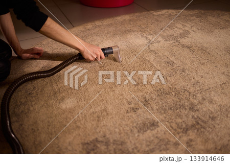 Maintenance technician performs thorough carpet extraction, Professional technician utilizes portable tool to deeply clean and rejuvenate stained commercial carpets Maintenance technician performs thorough carpet extraction, Professional technician utilizes portable tool to deeply clean and rejuvenate stained commercial carpets 133914646