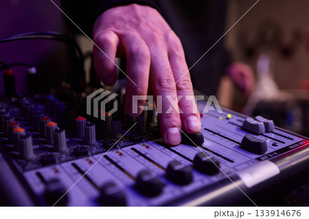Closeup of tactile controls and vibrant patch cords in studio, Adjusting analog sequencing equipment with bright cables and warm ambient lighting in home studio 133914676
