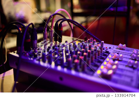 Engineer finetuning sound signals using patch cables, Focused technician adjusting levels on electronic patch cable setup with vivid colorful plugs and tactile interfaces 133914704