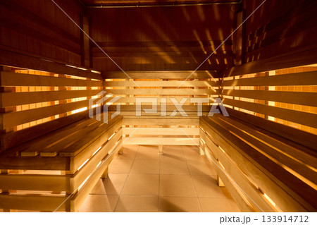 Relaxing wooden sauna ambiance, Serene sauna environment with warm lighting and seating, Inviting sauna space featuring soft glow and layered benches for relaxation Relaxing wooden sauna ambiance, Serene sauna environment with warm lighting and seating, Inviting sauna space featuring soft glow and layered benches for relaxation 133914712