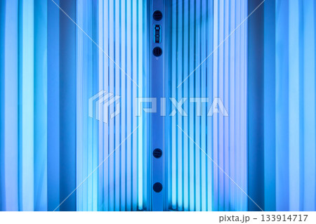 Modern therapeutic tanning setup, Elegant spa environment with ultraviolet illumination, Sophisticated cosmetic treatment station with illuminated UV lamps and sleek equipment Modern therapeutic tanning setup, Elegant spa environment with ultraviolet illumination, Sophisticated cosmetic treatment station with illuminated UV lamps and sleek equipment 133914717