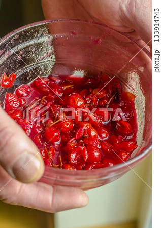 Hands Holding Bowl of Crushed Red Berries 133914743