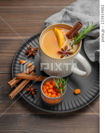 Sea buckthorn herbal tea in a cup on a black plate on a wooden background Sea buckthorn herbal tea in a cup on a black plate on a wooden background 133914862