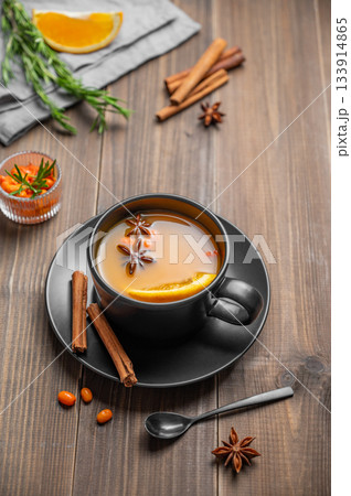 Sea buckthorn herbal tea in a black cup on a wooden background with spices Sea buckthorn herbal tea in a black cup on a wooden background with spices 133914865