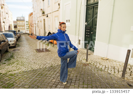 Dynamic performer on city street showcasing expressive dance movements 133915457