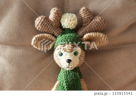 Crocheted Christmas Reindeer Standinng on Cozy Holiday Background Crocheted Christmas Reindeer Standinng on Cozy Holiday Background 133915541