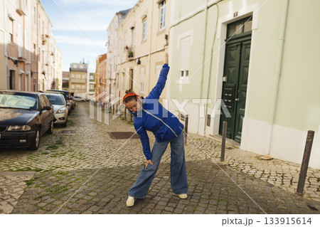 Person engaged in energetic dance on historic city street 133915614