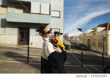 Charming city picture of woman and her small pet in casual attire Charming city picture of woman and her small pet in casual attire 133915835