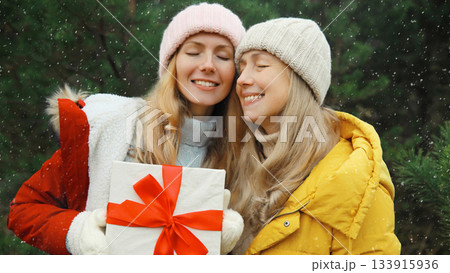 Winter happy women friends holding gift box, celebration, joyful girlfriends together in Christmas Winter happy women friends holding gift box, celebration, joyful girlfriends together in Christmas 133915936