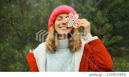 Winter portrait of happy smiling woman with snowflakes having fun enjoys snow against Christmas tree 133915959