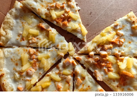Delicious slices of pizza with chicken and pineapple on a sunny day 133916006