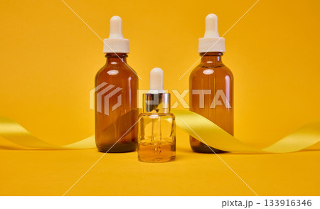 Various glass bottles with pipettes containing cosmetic serums or oils. Various glass bottles with pipettes containing cosmetic serums or oils. 133916346