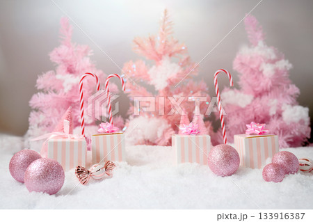 Pink Winter Wonderland. A festive scene with pink trees, gifts, and candy canes Pink Winter Wonderland. A festive scene with pink trees, gifts, and candy canes 133916387