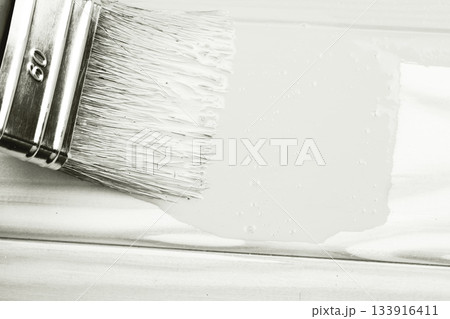 Paintbrush applying white paint to wooden surface. Color of 2026 year dancer in the white cloud 133916411
