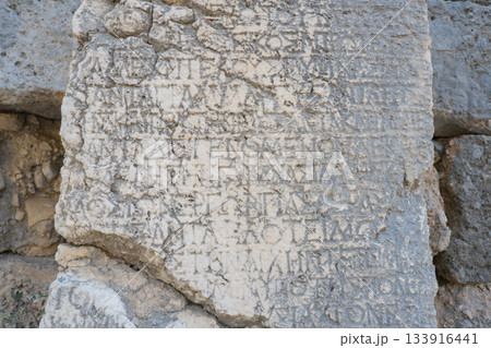 Ancient stone column with inscriptions and hieroglyphs. Antique landmark. Turkey, Kemer, Phaselis 133916441