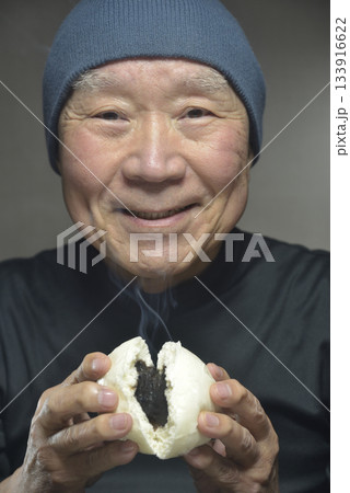 湯気の立ち昇るあんまんを笑顔で食べる老人 湯気の立ち昇るあんまんを笑顔で食べる老人 133916622