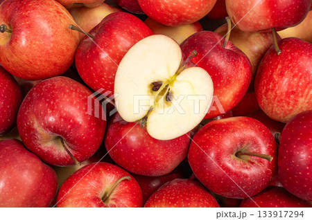 A group of red gala apples viewed from above with a slice cut into the center 133917294