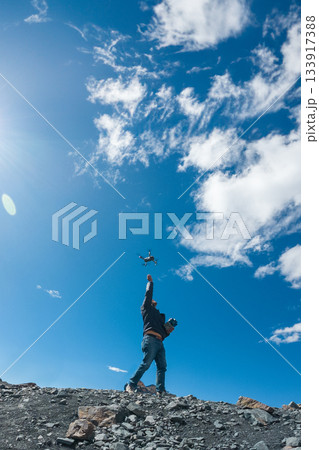 A man is flying a drone in the sky 133917388