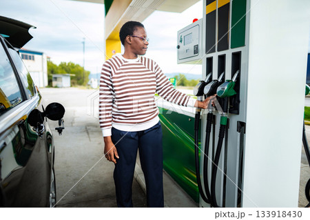 African american woman fueling car at gas station African american woman fueling car at gas station 133918430