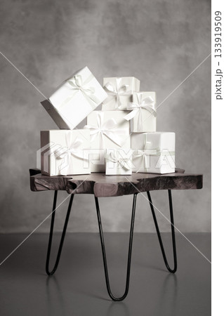 White gifts with ribbons stacked on wooden table. Color of 2026 year dancer in the white cloud White gifts with ribbons stacked on wooden table. Color of 2026 year dancer in the white cloud 133919509