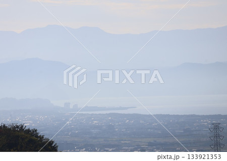 朝霞みの中の田畑と街並みと海と山並みと空の風景 133921353