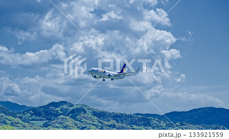 夏雲と山並みを背に飛ぶ飛行機 夏雲と山並みを背に飛ぶ飛行機 133921559