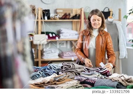 Young girl choosing sweater in clothing store Young girl choosing sweater in clothing store 133921706