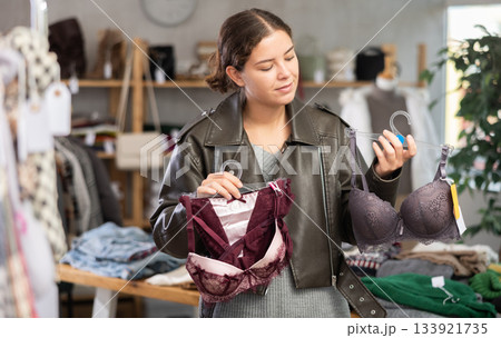 Attractive female customer choose new bra in boutique 133921735