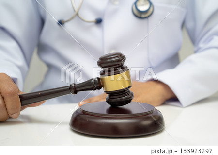 Doctor holding judge gavel, forensic medicine, medical law and crime justice. Doctor holding judge gavel, forensic medicine, medical law and crime justice. 133923297