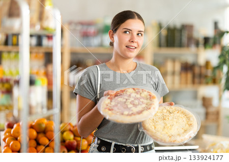 Young woman choosing pizza in grocery store Young woman choosing pizza in grocery store 133924177