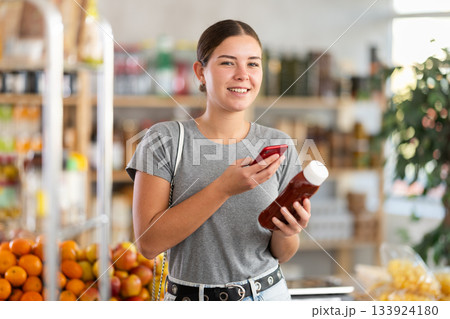 Young woman scanning qr code for ketchup Young woman scanning qr code for ketchup 133924180