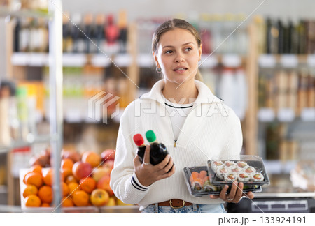 European woman chooses soy sauce for sushi European woman chooses soy sauce for sushi 133924191