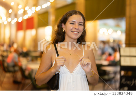 In night, young smiling girl walks along city street Ferran 133924349