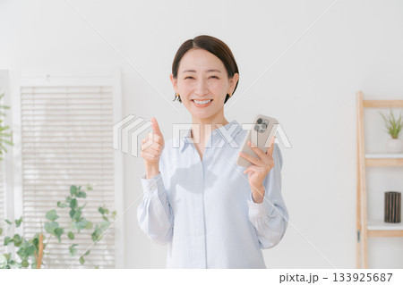 スマホを持つ40代女性 133925687