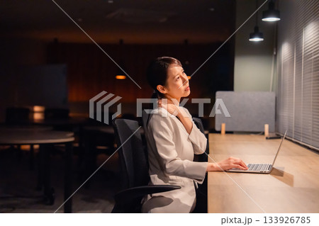 オフィスで暗くなるまで残業をして疲れる女性管理職 133926785
