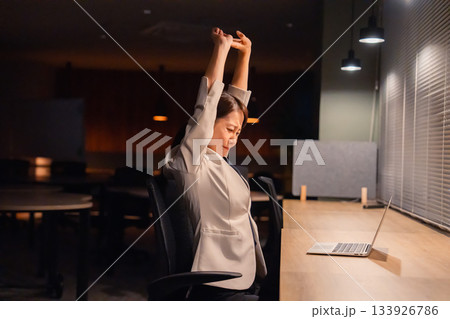 オフィスで暗くなるまで残業をして疲れる女性管理職 133926786